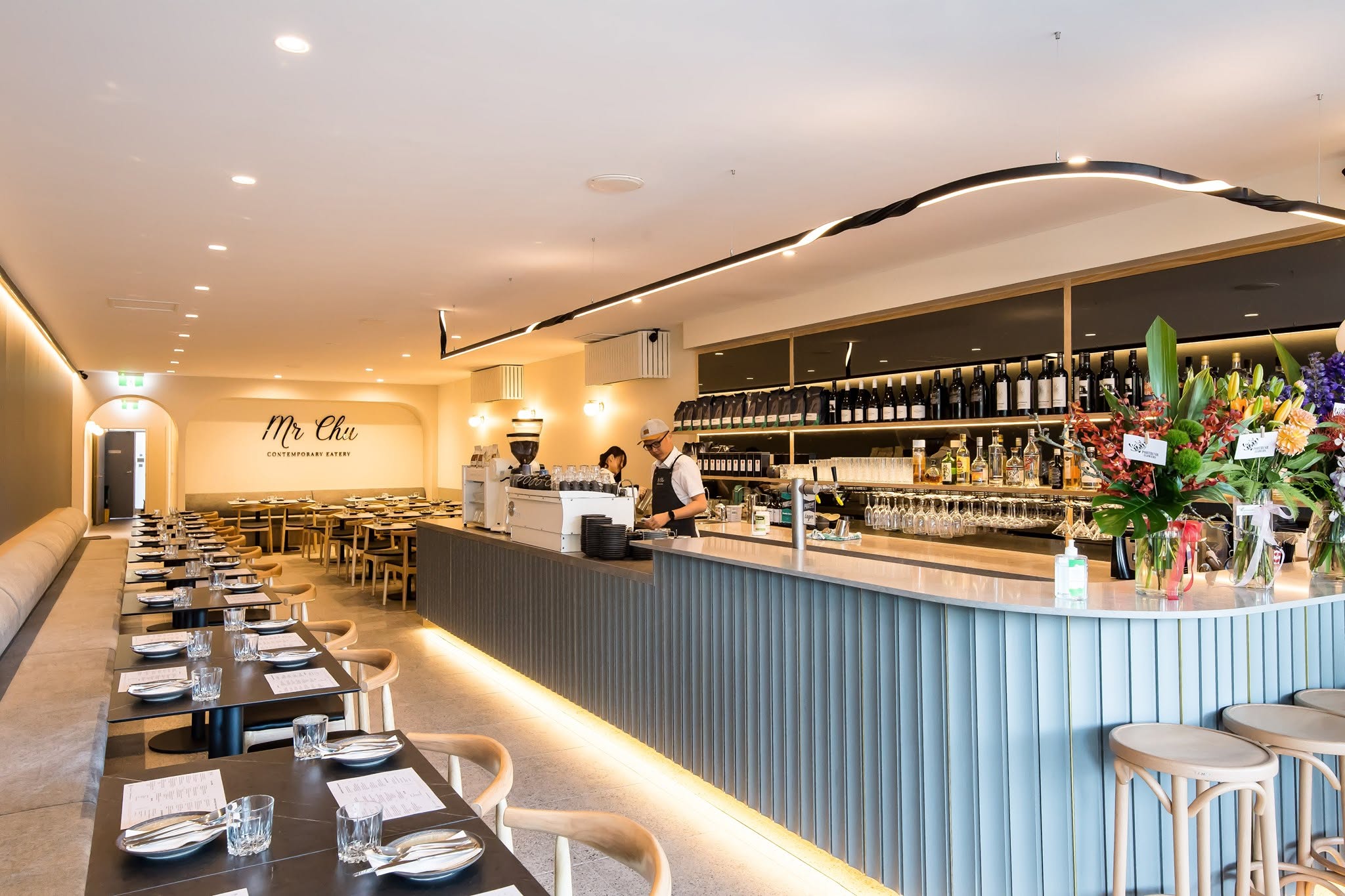 Inside Mr Chu Norwood: the arched room, the script sign on the wall and the pale blue bar